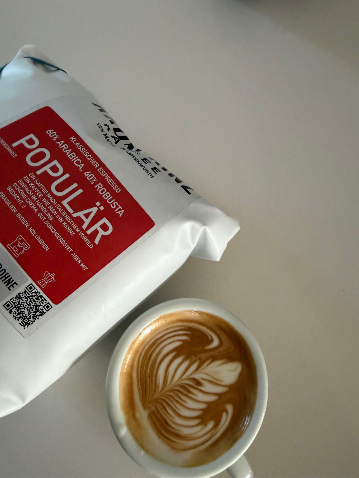 Populär: 1-kg-Beutel neben einem Cappuccino mit Latte Art
